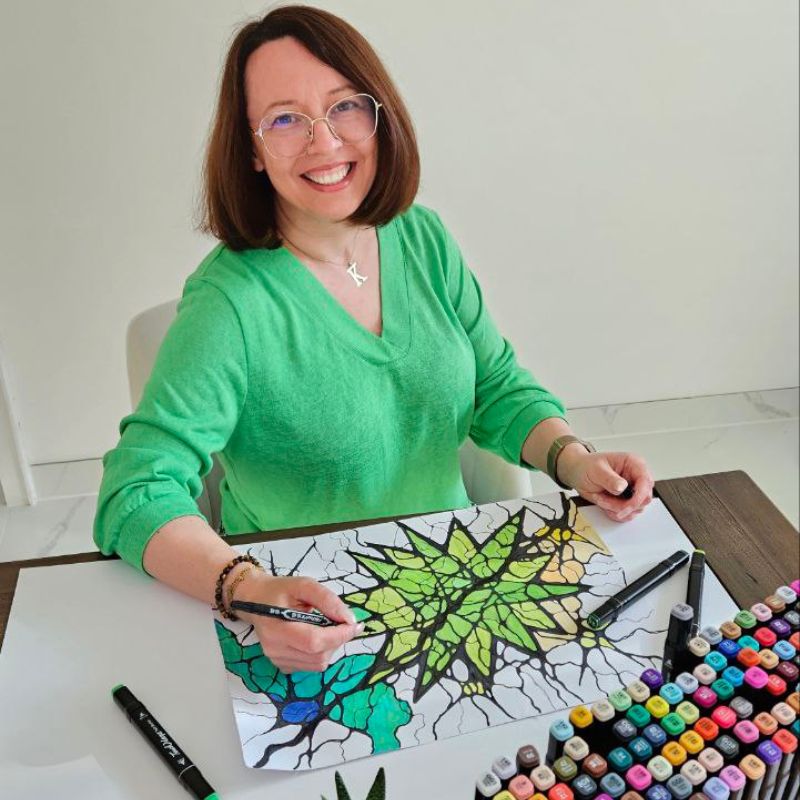 Pani Katarzyna tworzy zielono-niebieską neurografikę przy biurku.